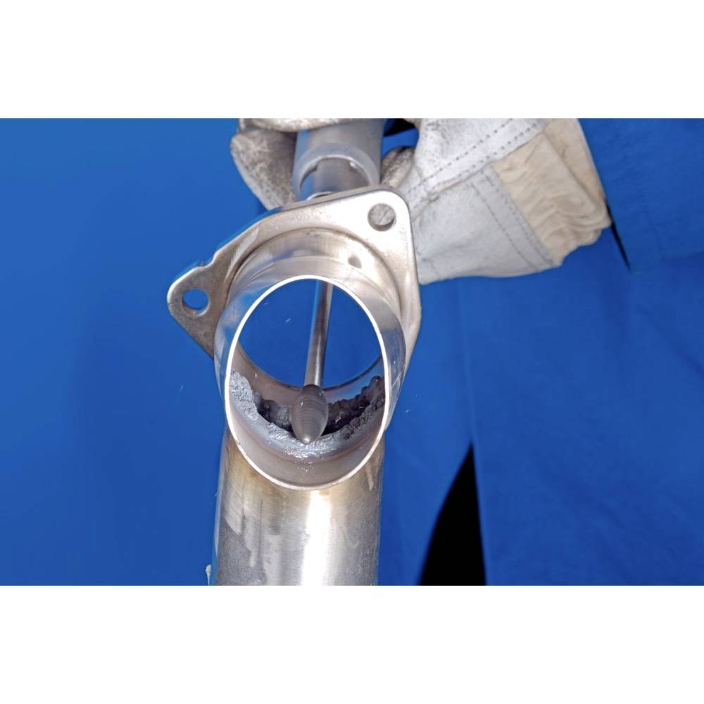 Osoba szlifuje wnętrze metalowej rury elektronarzędziem, podczas gdy nosi rękawice ochronne.