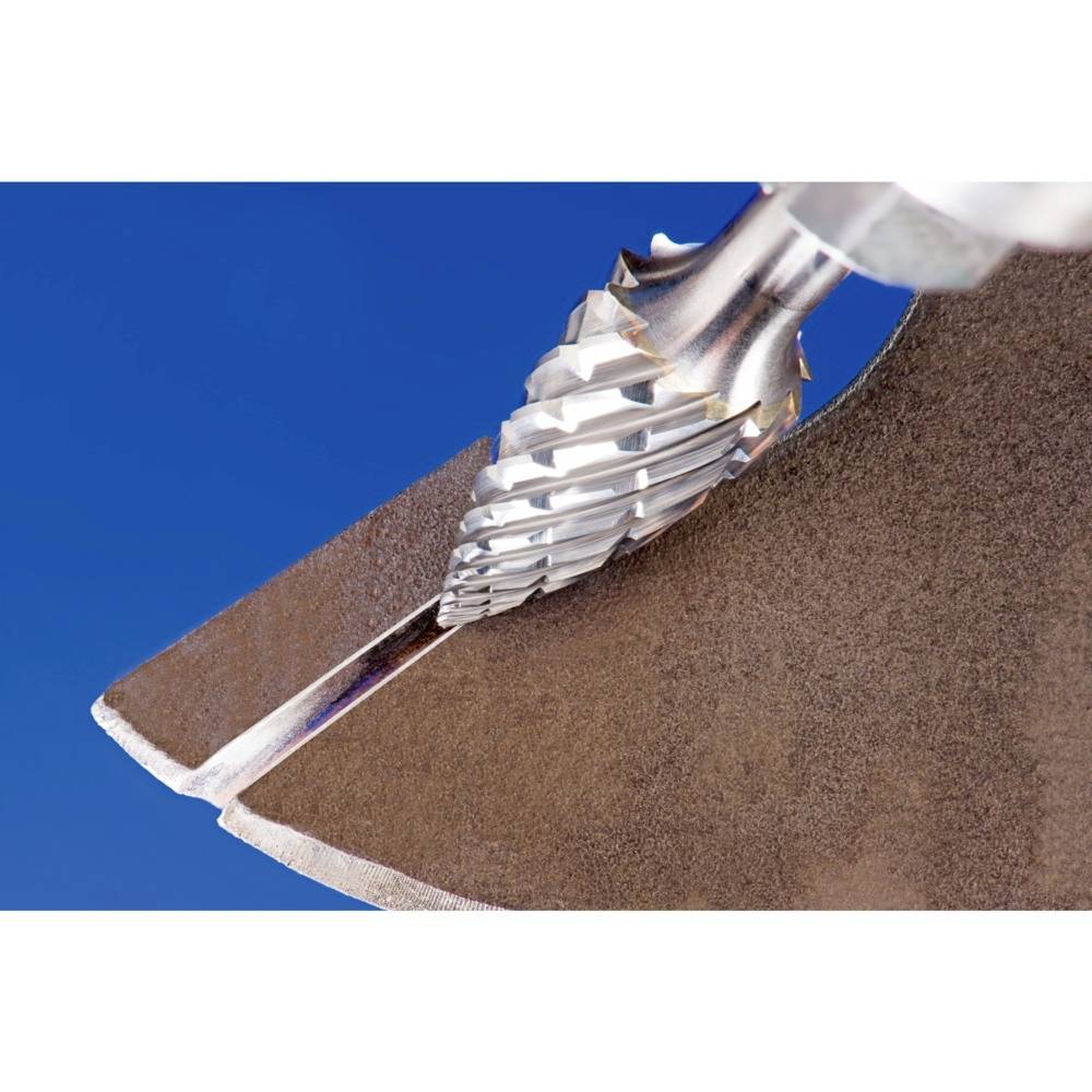 Zbliżenie głowicy wiertniczej z ostrymi, śrubowymi krawędziami tnącymi do obróbki metalu na niebieskim tle.