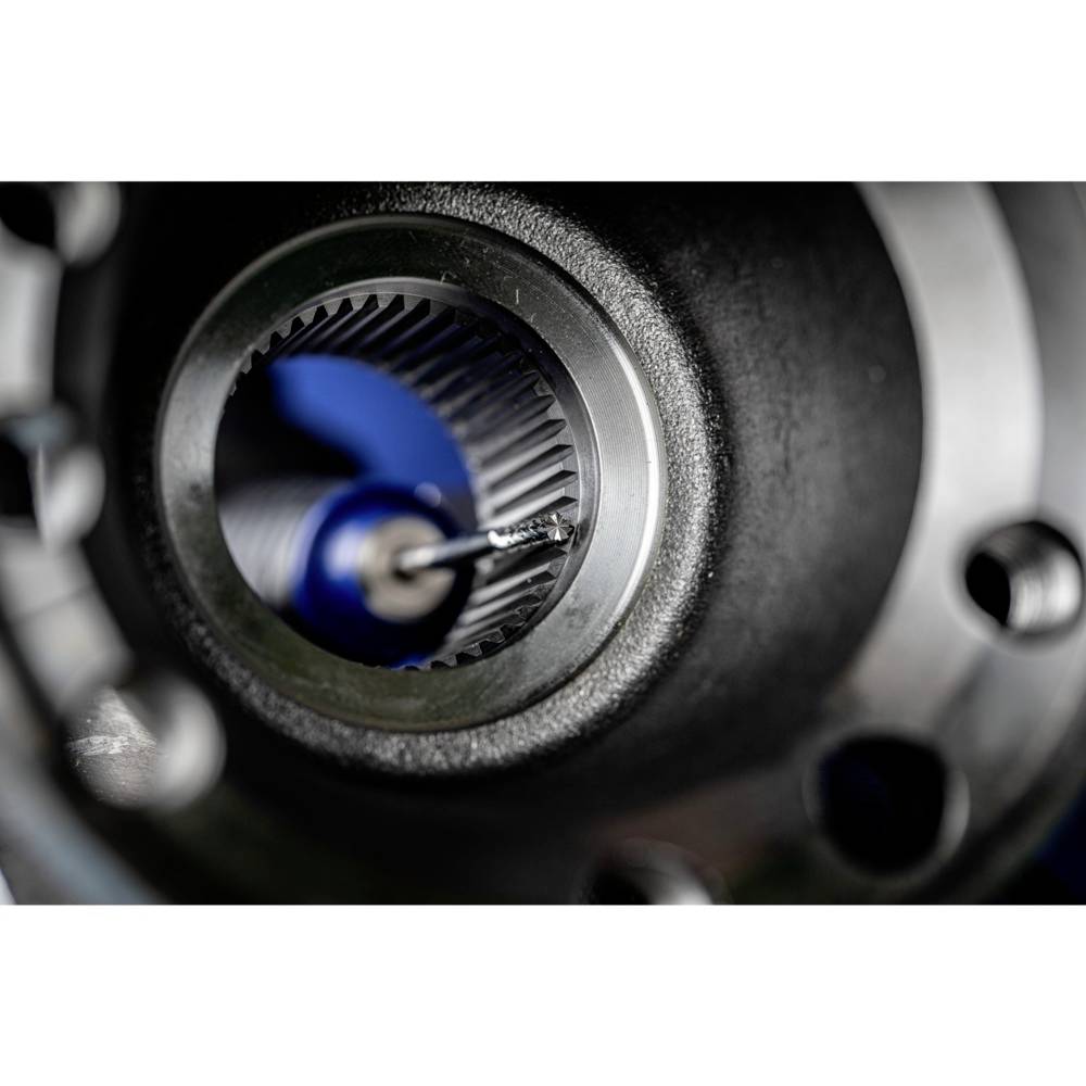 Zbliżenie elementu mechanicznego z cylindrycznym wnętrzem i uzębionym obrzeżem, prawdopodobnie będącego częścią przekładni lub silnika.