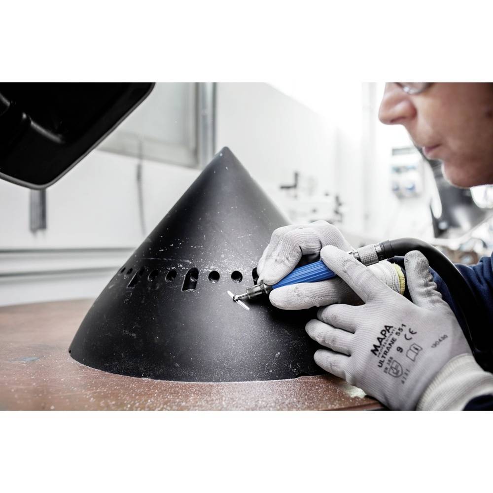 Osoba pracuje narzędziem przy dużym, czarnym stożku metalowym, prawdopodobnie w celu precyzyjnej obróbki lub naprawy.