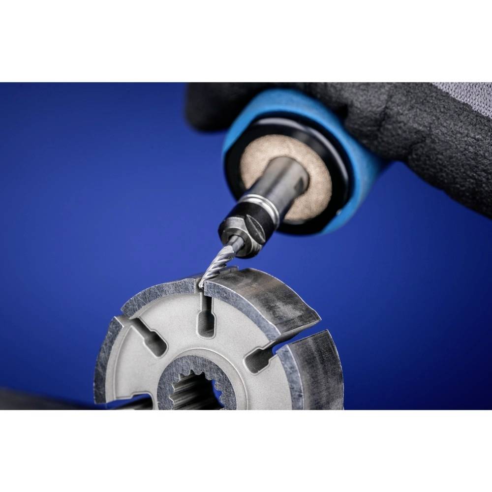 Zbliżenie wiertła obrabiającego metalową tarczę. Tło jest niebieskie. Nacisk na precyzję i technikę wytwarzania.