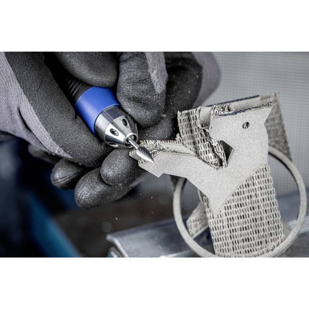 Zbliżenie osoby obrabiającej element metalowy precyzyjnym niebieskim narzędziem w rękawiczkach.