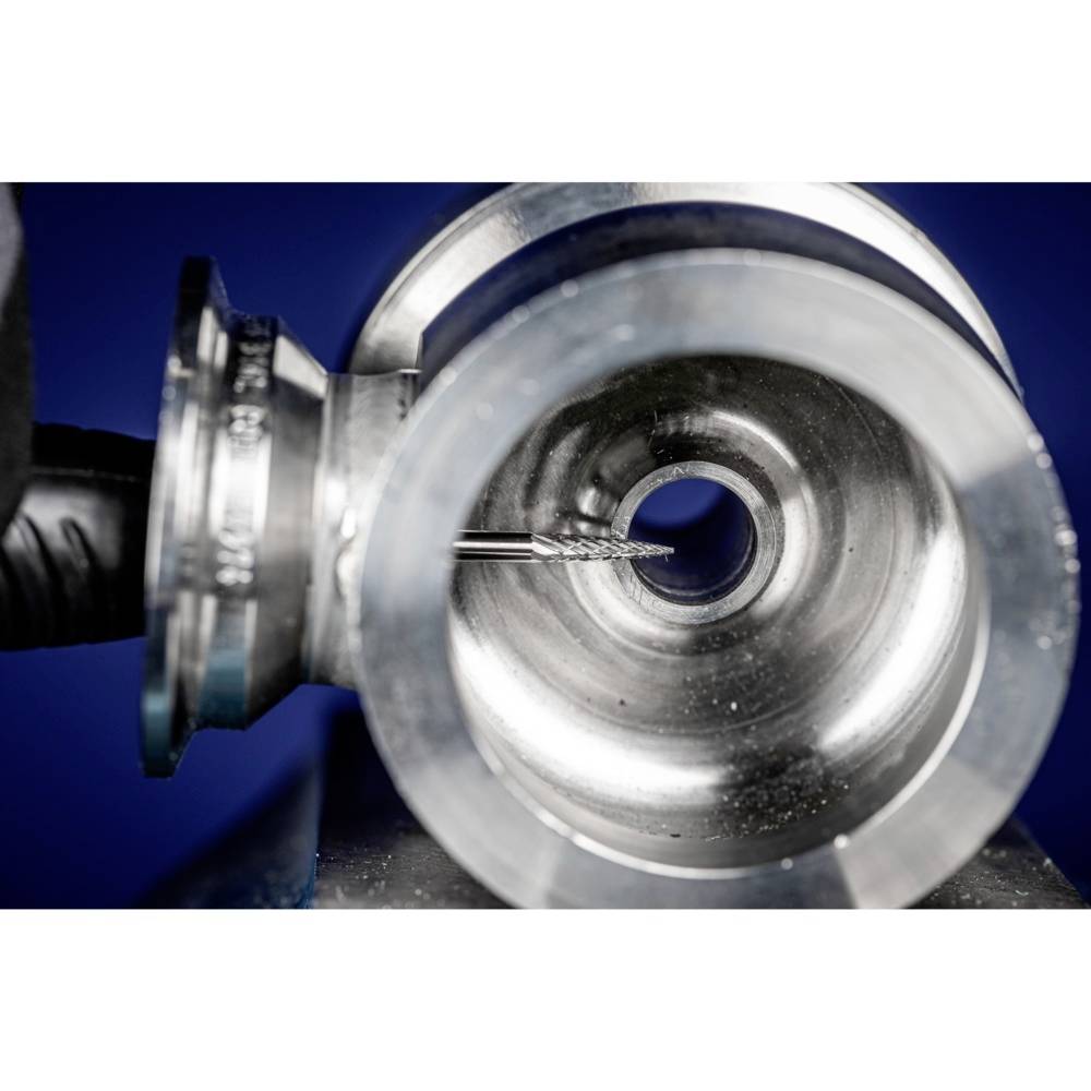 Zbliżenie maszyny do obróbki metalu precyzyjnie szlifującej cylindryczny otwór wewnętrzny. Widok na narzędzie szlifierskie i powierzchnię metalu.