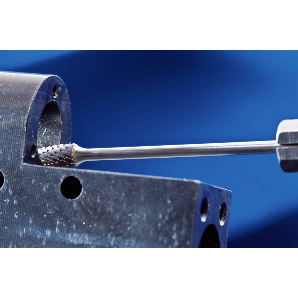 Metalowy wiertarz obrabia okrągły element roboczy na niebieskim tle.