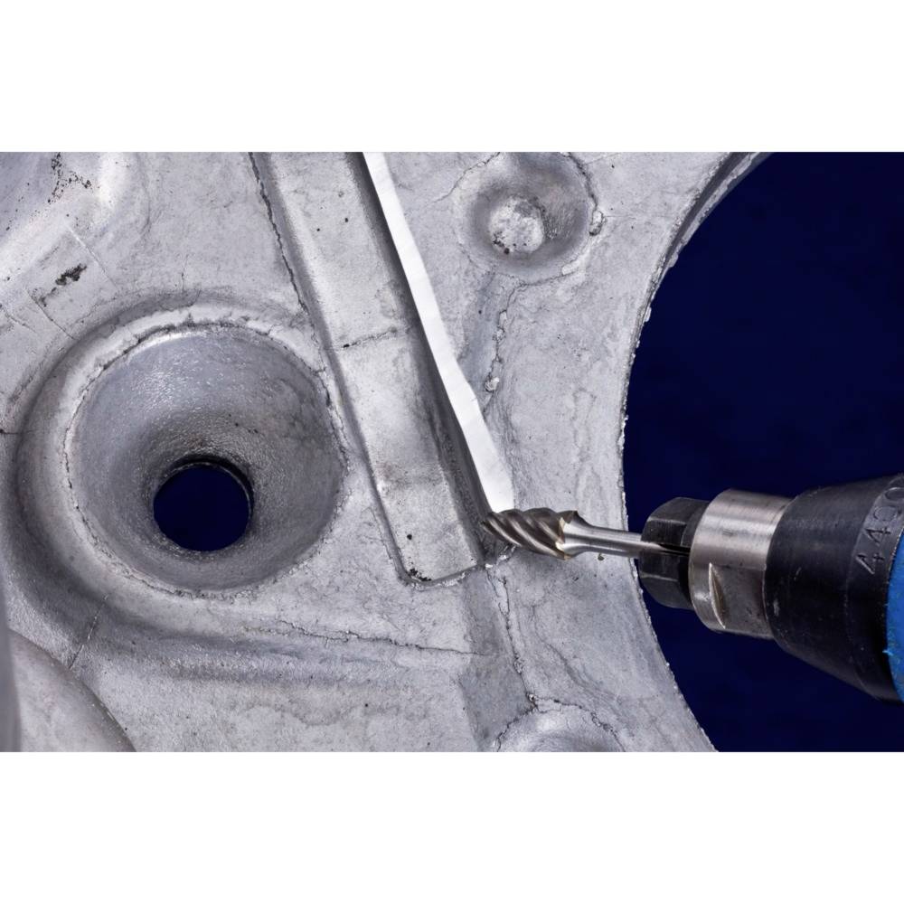 Wiertło obrabia powierzchnię metalową. Po lewej stronie znajduje się małotwór, po prawej wiertło wchodzące w powierzchnię.