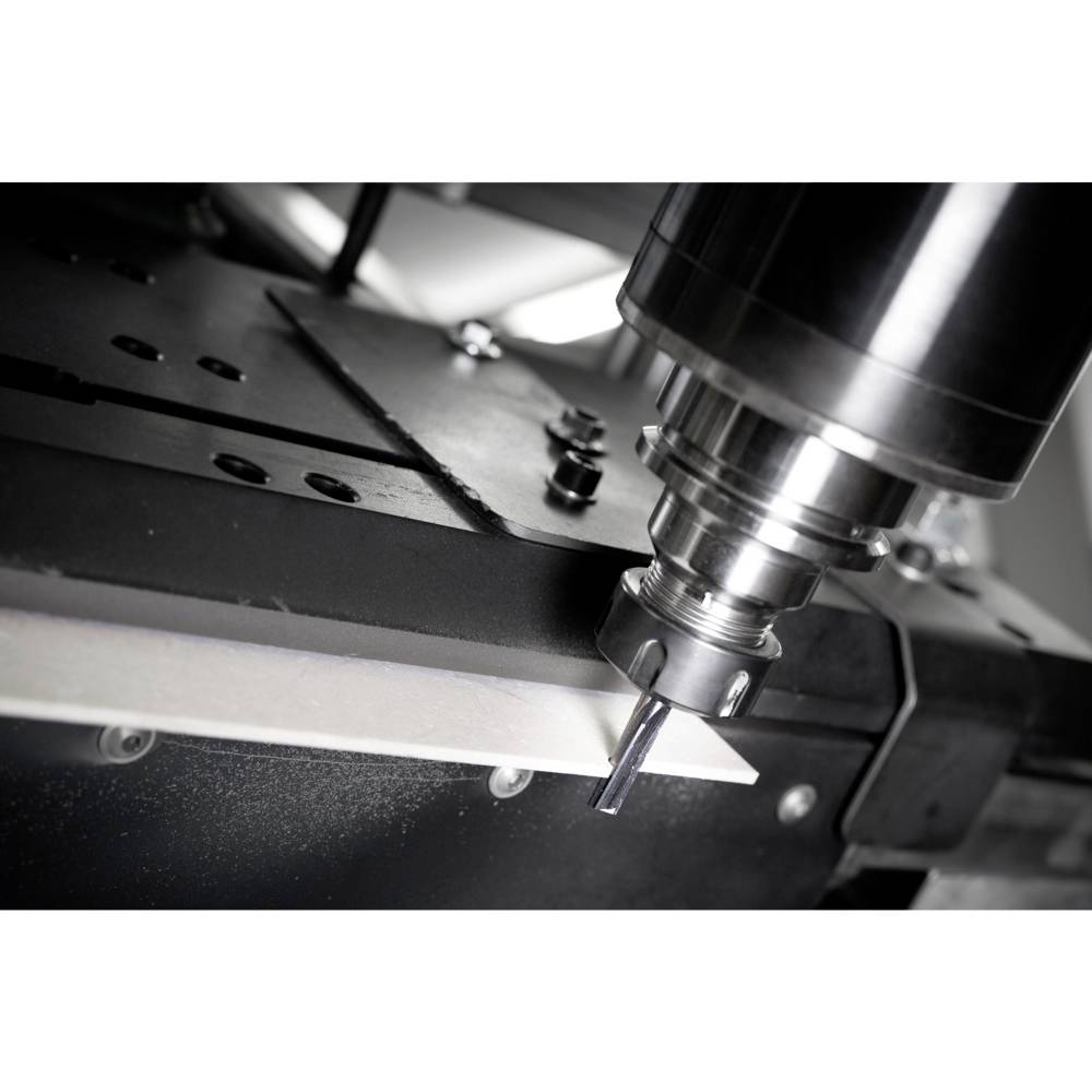 Zbliżenie na pracującą frezarkę CNC, która wykonuje precyzyjne cięcie elementu metalowego.