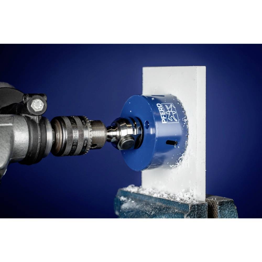 Niebieska piła otwornica wycina okrągły otwór w białym materiale, będąc zamocowaną na głowicy wiertniczej.