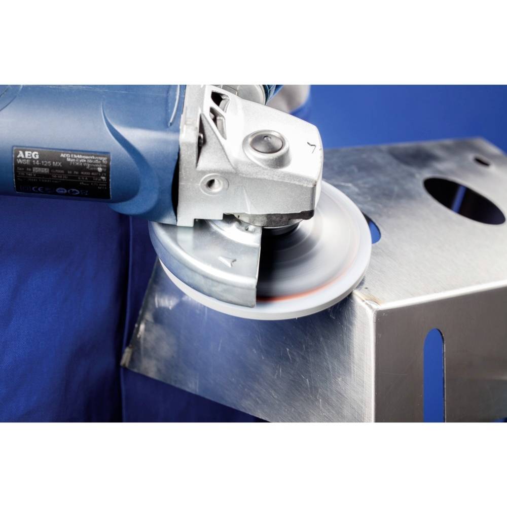 Elektryczna szlifierka szlifuje krawędź kawałka metalu. Podczas szlifowania mogą powstawać iskry.