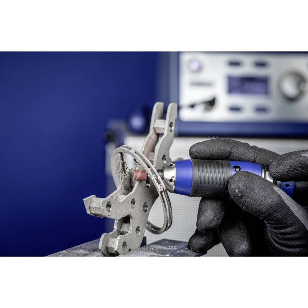 Osoba poleruje obiekt metalowy niebieskim narzędziem Dremel na niebieskim tle. W centrum uwagi jest precyzyjna praca.