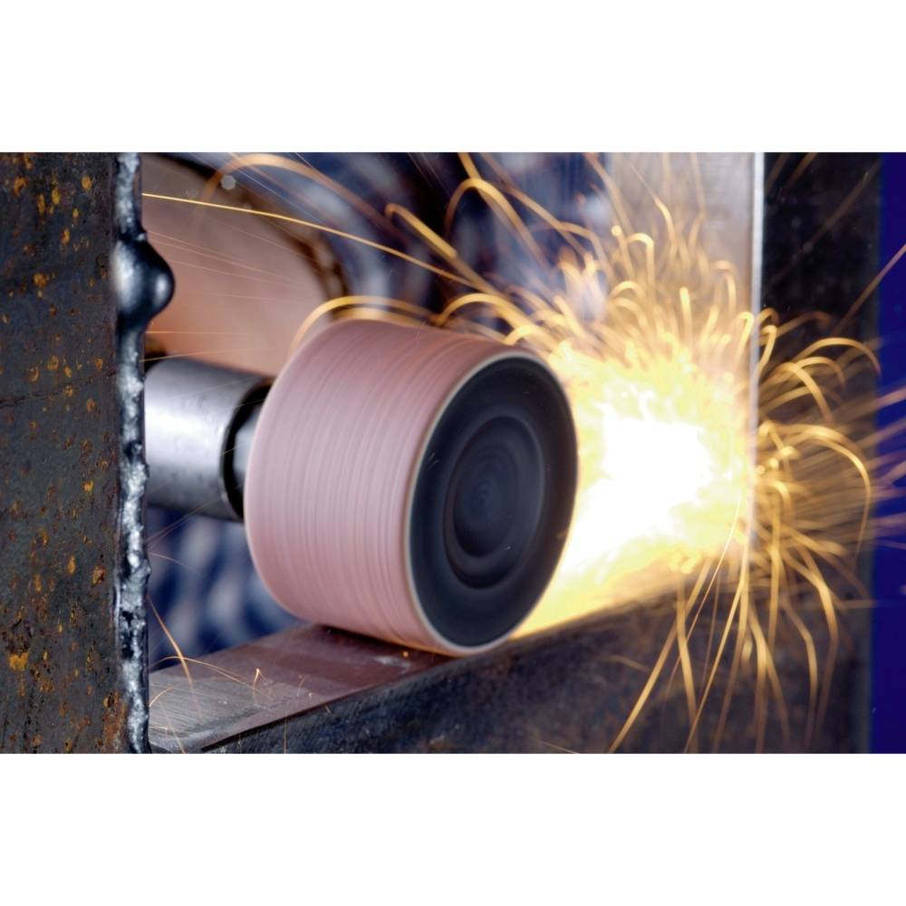 Narzędzie szlifierskie obrabia krawędź części metalowej, podczas gdy iskry lecą.