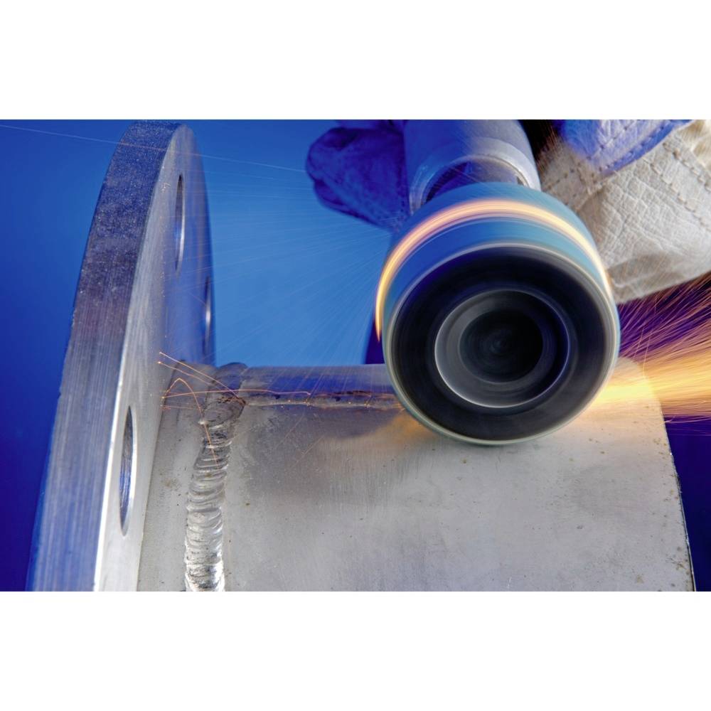 Robotnik szlifuje metalową powierzchnię obrotowym narzędziem ściernym, iskry tryskają na niebieskim tle.