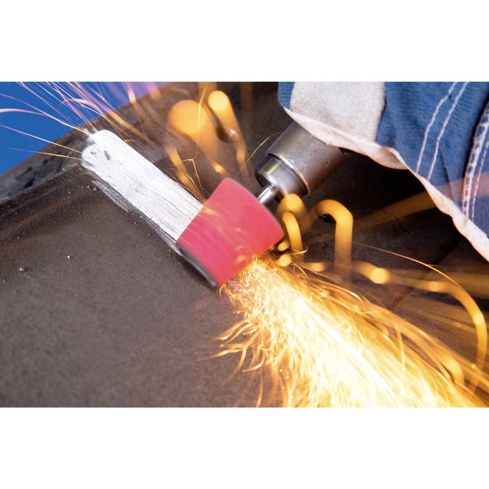 Osoba szlifuje metal elektryczną szlifierką; lecą iskry. Widoczne są ubranie robocze i środki ochronne.