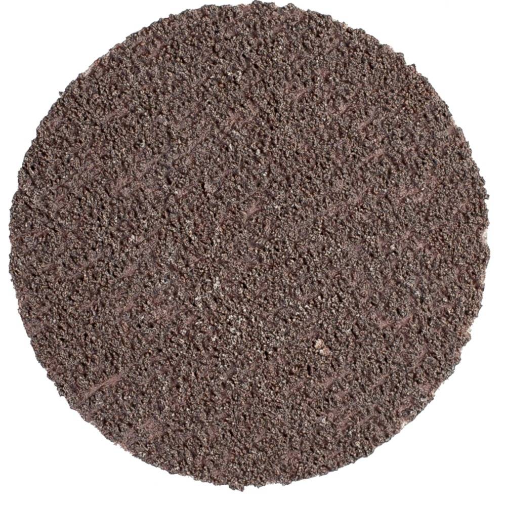 Zbliżenie okrągłej, brązowej tarczy szlifierskiej o chropowatej, ziarnistej powierzchni. Używana jest do obróbki metalu lub drewna.