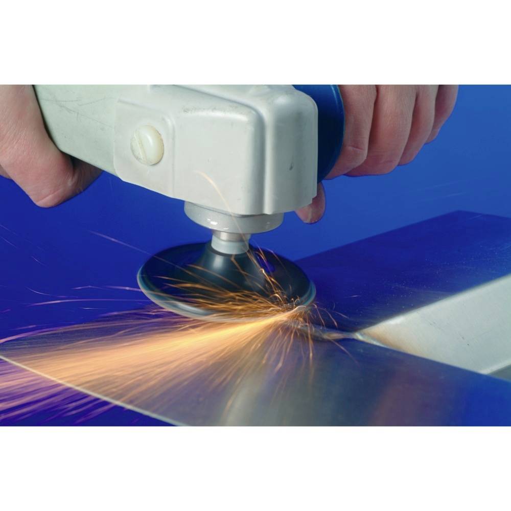 Ręka szlifuje metal maszyną, iskry tryskają.