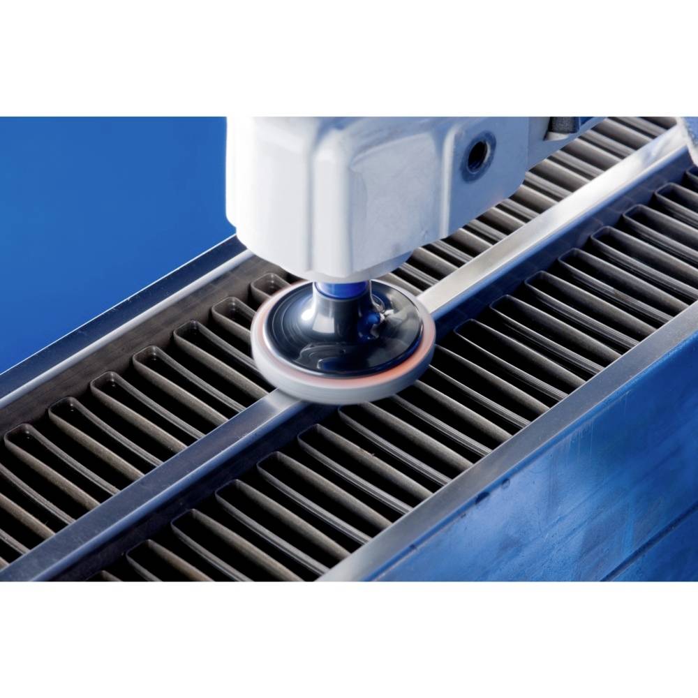 Ramię robota poleruje powierzchnię metalową za pomocą obrotowej tarczy, aby ją wygładzić i wykończyć.