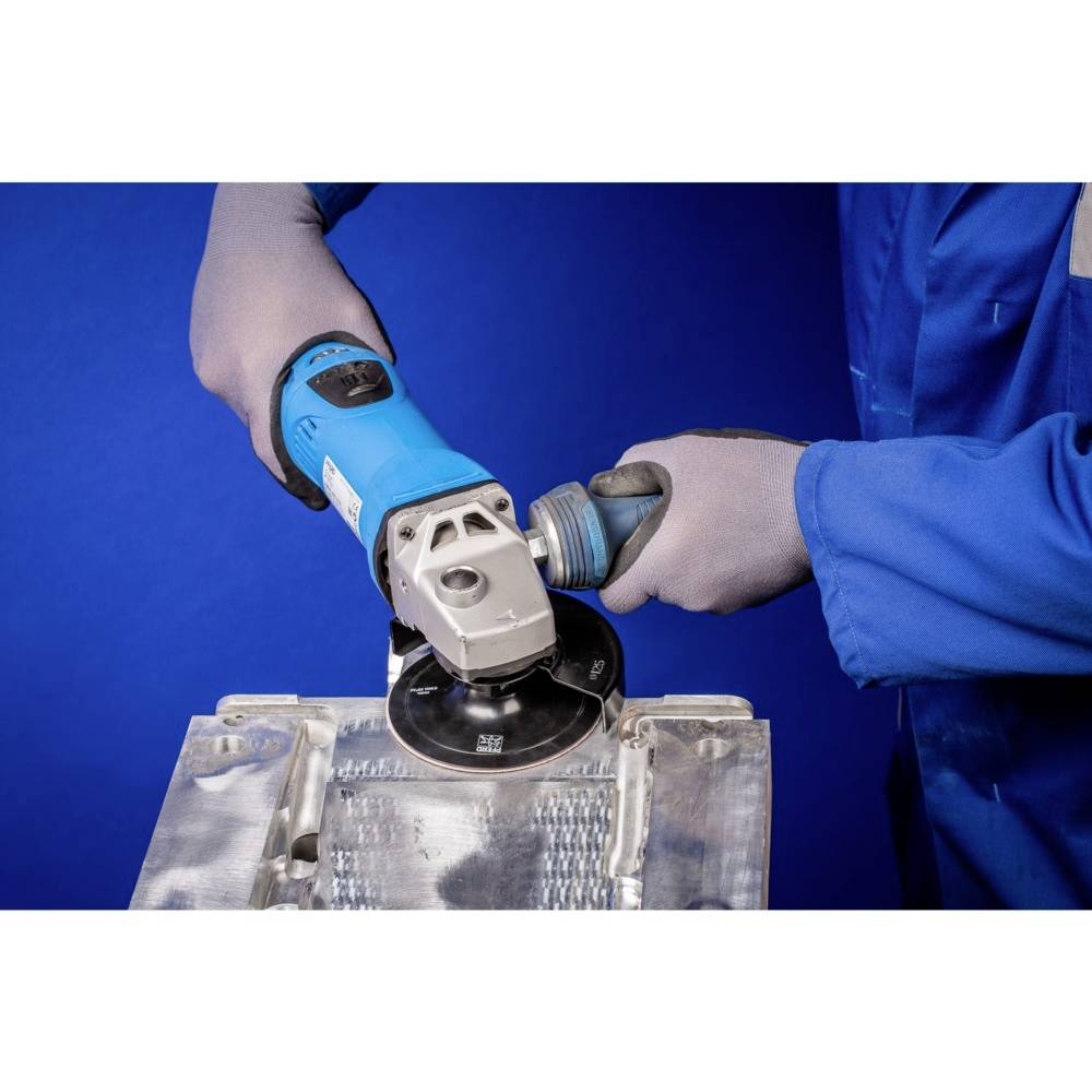 Osoba ubrana w niebieskie ubranie robocze używa szlifierki kątowej do obróbki powierzchni metalowej. Wyposażona jest w sprzęt ochronny.