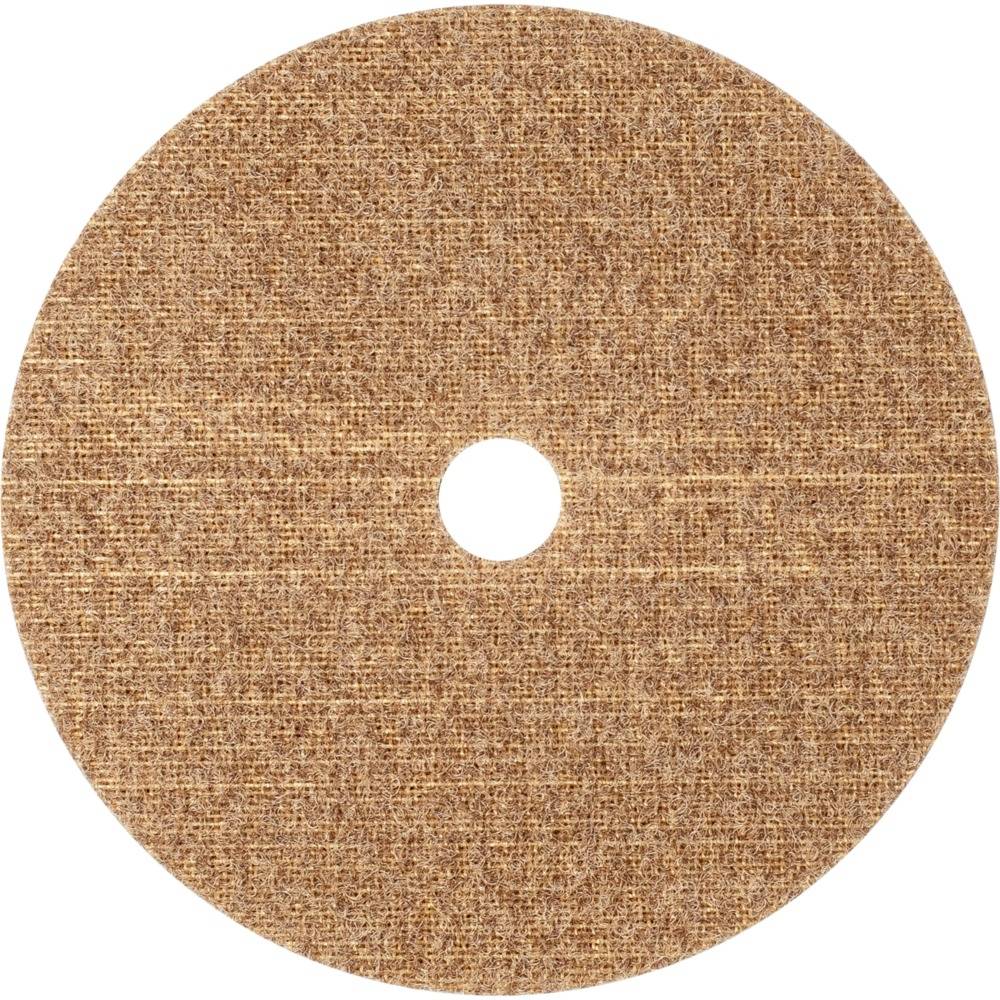 Brązowa okrągła tarcza szlifierska z otworem pośrodku, leżąca na białej powierzchni.