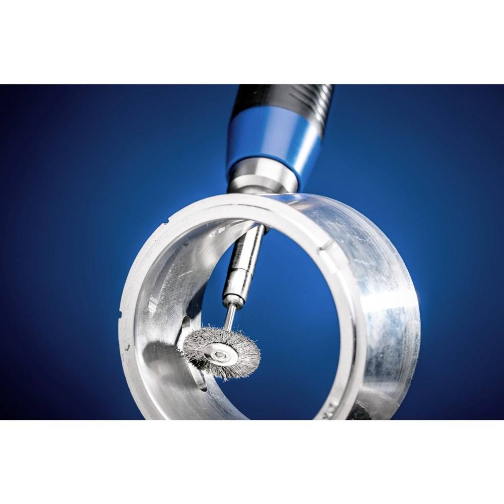 Obracające się narzędzie z tarczą drucianą obrabia metalową, cylindryczną powierzchnię na niebieskim tle.