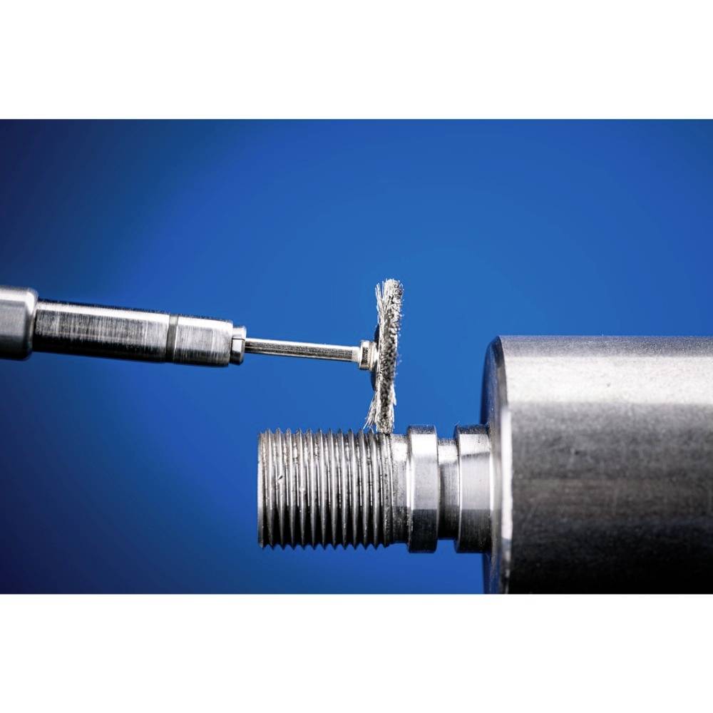 Element metalowy jest polerowany obracającą się tarczą szlifierską. Fokus spoczywa na tarczy szlifierskiej i obrabionym gwincie.