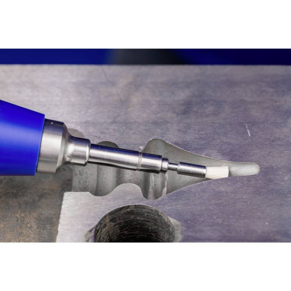 Niebieski uchwyt narzędzia obrabia powierzchnię metalu poprzez frezowanie, tworząc gładkie krawędzie. W tle widoczne są wióry metalowe.