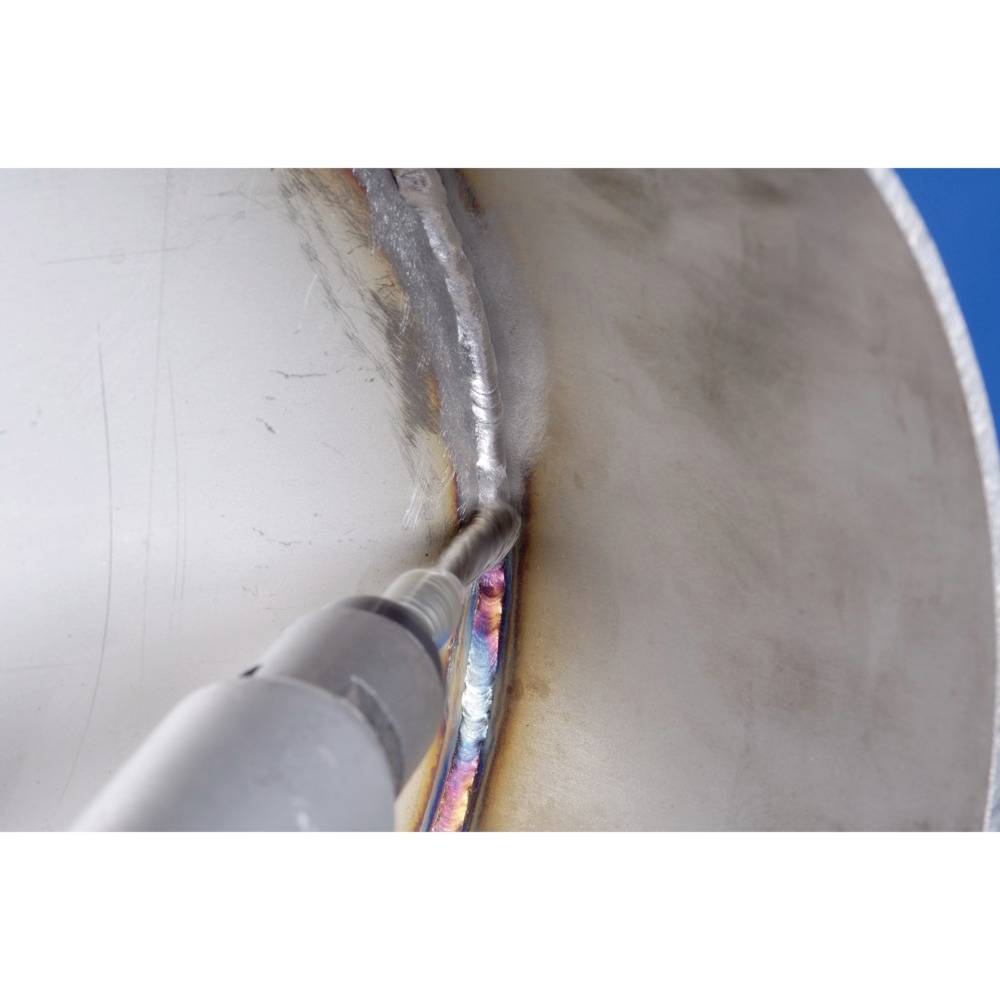 Zbliżenie procesu spawania na powierzchni metalowej. Urządzenie spawalnicze tworzy precyzyjny, kolorowy spaw pod określonym kątem.