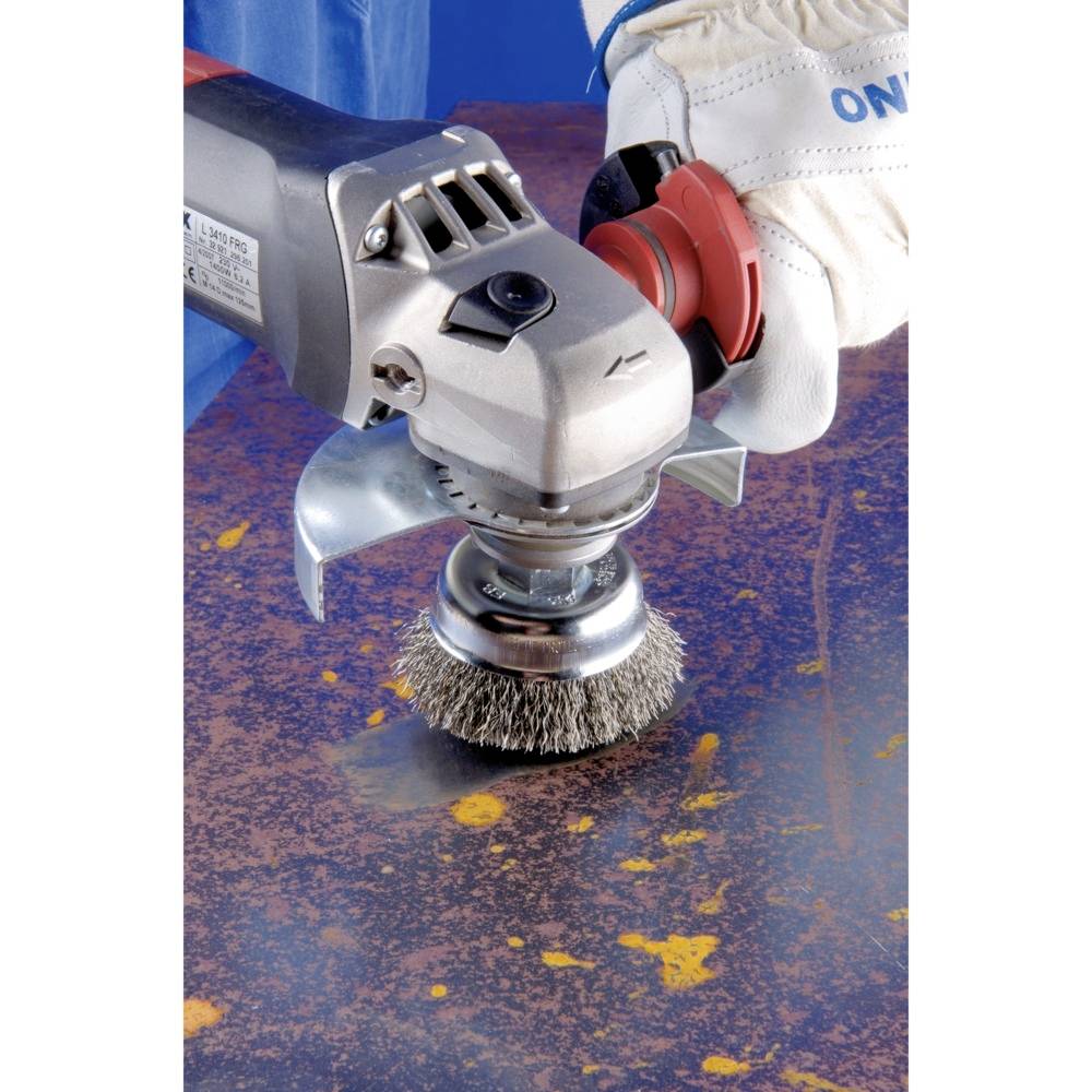 Osoba używa elektrycznej szczotki drucianej do usuwania rdzy z powierzchni metalowej.