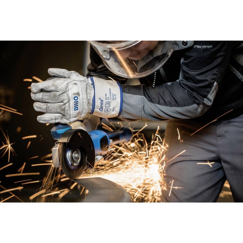 Robotnik ucina kawałek metalu szlifierką kątową, podczas gdy iskry się sypią. Robotnik jest ubrany w odzież ochronną.