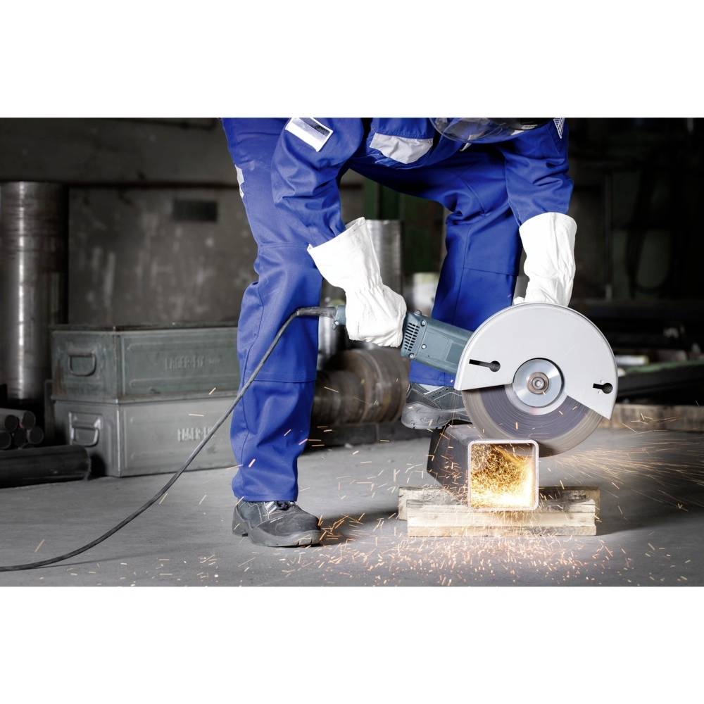 Osoba ubrana w niebieskie ubranie ochronne i białe rękawice używa szlifierki do cięcia metalu, powodując przy tym lot iskier.
