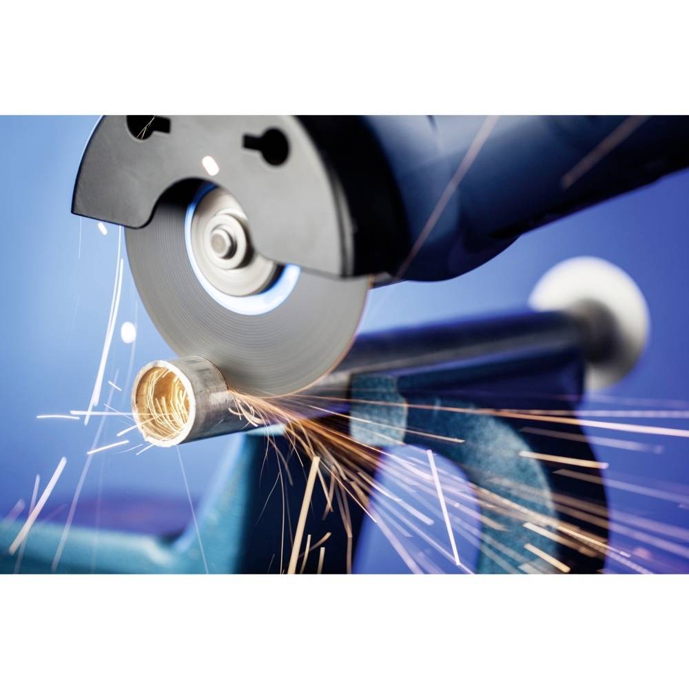 Elektryczna szlifierka tnie rurę metalową, a wokół sypią się iskry. Rura jest zamocowana w imadle.