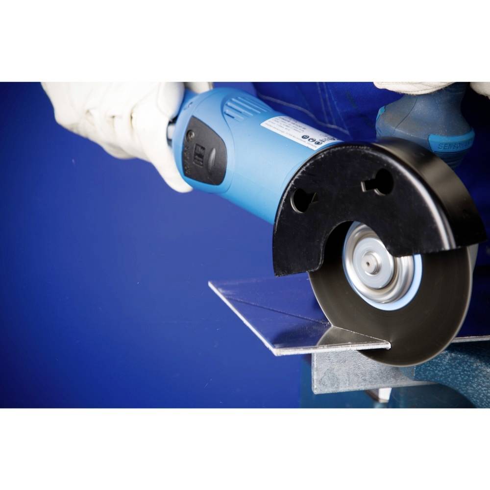 Osoba ucina kawałek metalu niebieską szlifierką kątową. Od miejsca cięcia odpryskują iskry.