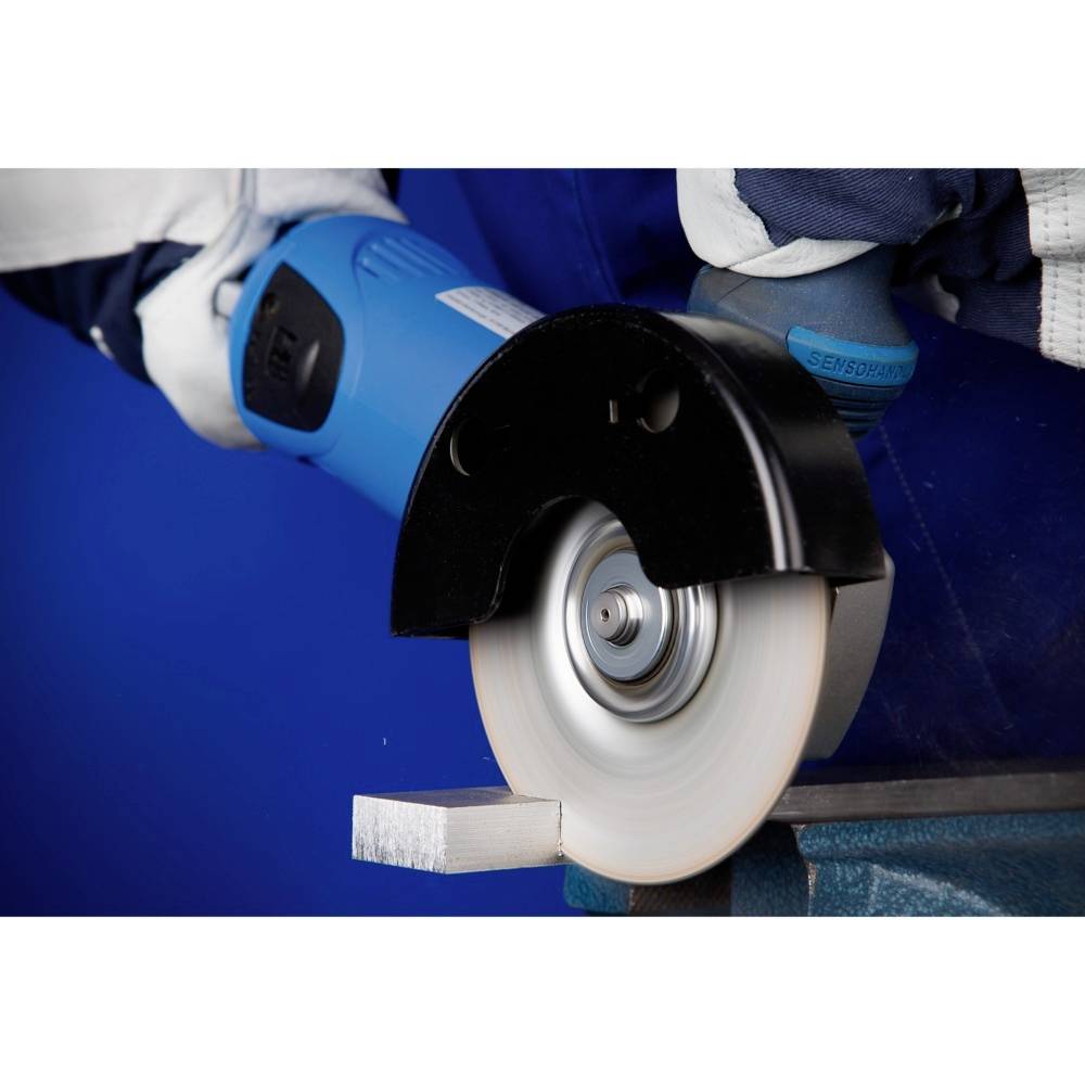 Osoba używa szlifierki kątowej do obróbki kawałka metalu. Podczas szlifowania powstają iskry i pył.