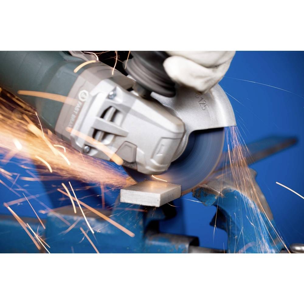 Szlifierka kątowa tnie metal. Iskry tryskają we wszystkich kierunkach. Pracownik nosi rękawice ochronne.