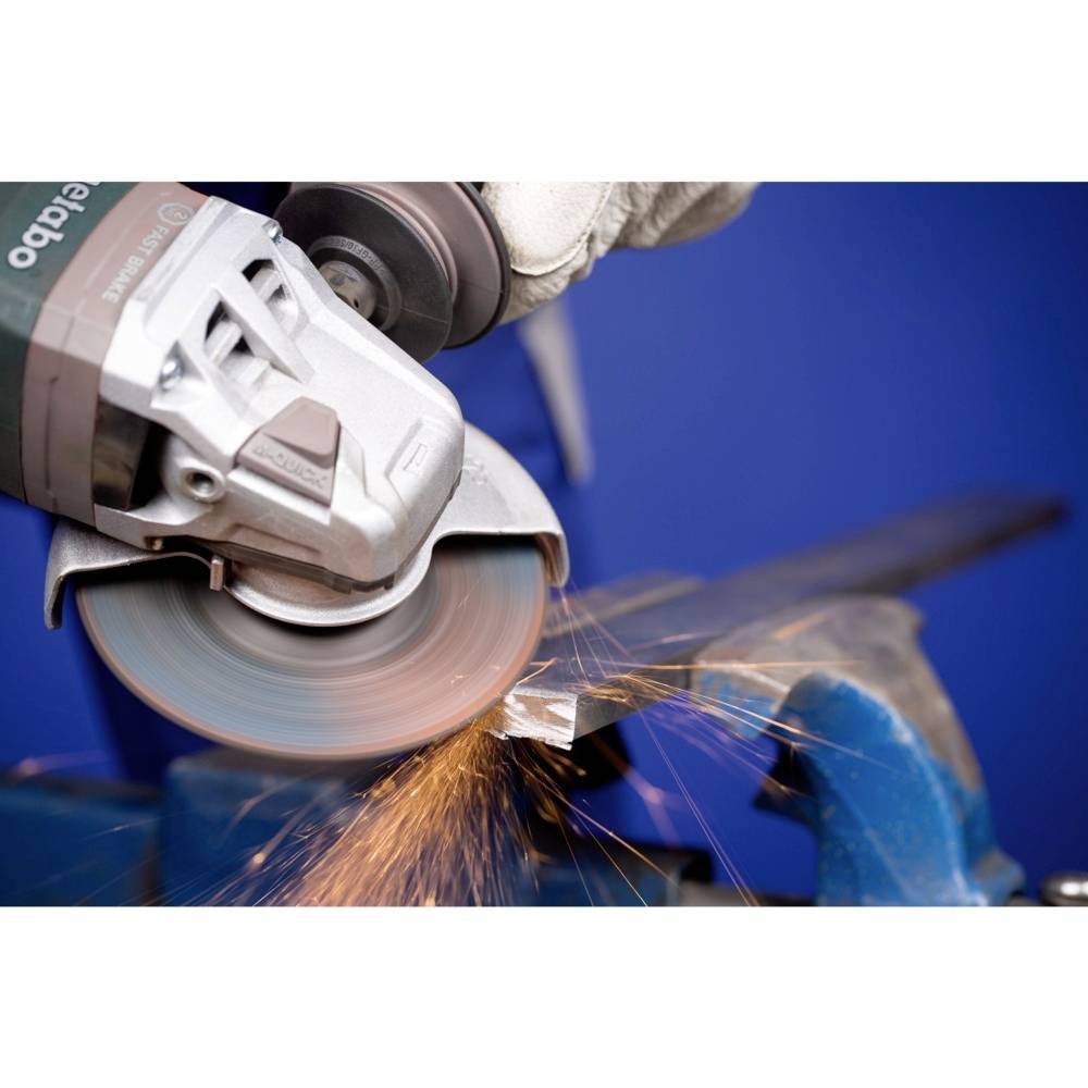 Osoba tnie kawałek metalu szlifierką kątową. Lecą iskry. Zbliżenie w środowisku warsztatu.