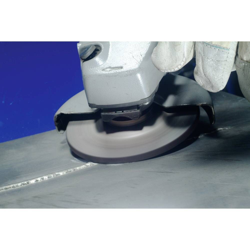 Robotnik szlifuje powierzchnię metalu szlifierką, ujęcie z bliska, pokazujące powstawanie iskier i obróbkę materiału.