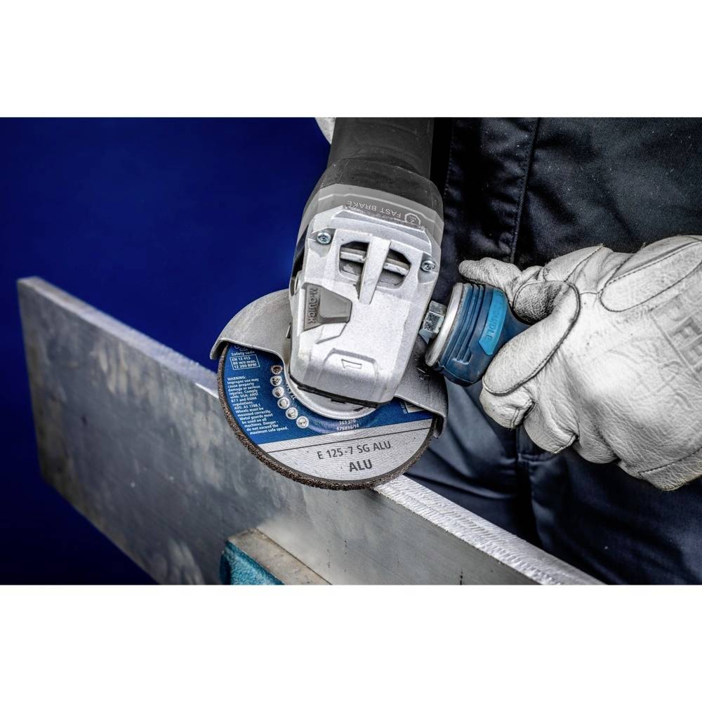 Osoba przecina metal szlifierką kątową. Nosi rękawice ochronne i pewnie trzyma narzędzie.