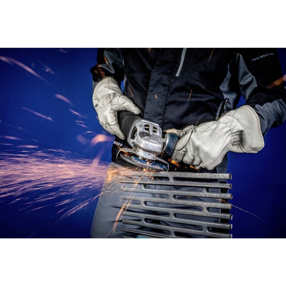 'Osoba szlifuje metal szlifierką. Sypią się iskry, osoba nosi rękawice ochronne. Tło jest niebieskie.'