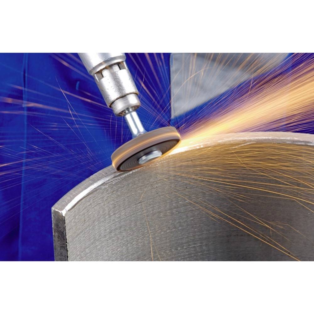 Narzędzie szlifierskie obrabia kawałek metalu, a wokół lecą iskry. Scena przedstawia precyzyjną obróbkę metalu w środowisku warsztatu.