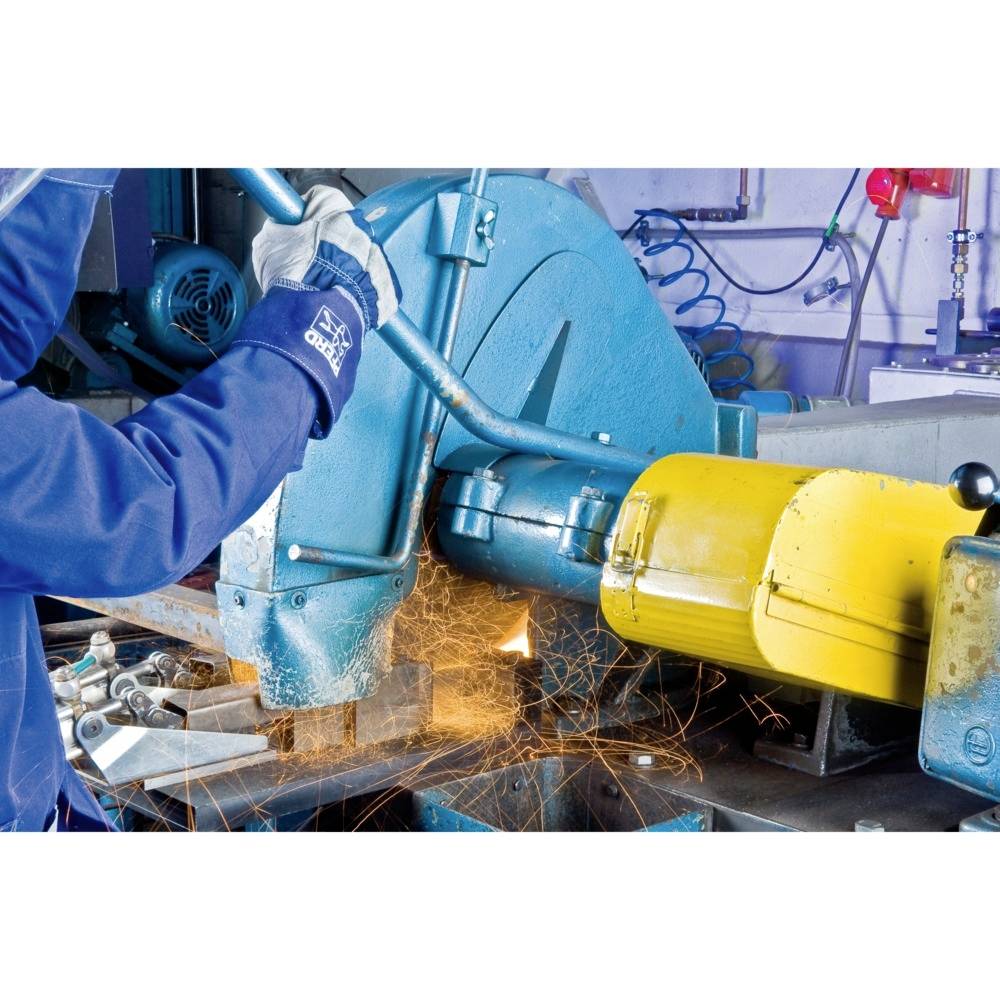 Robotnik w rękawicach przecina metalowe rury piłą wytwarzającą iskry w warunkach warsztatowych.