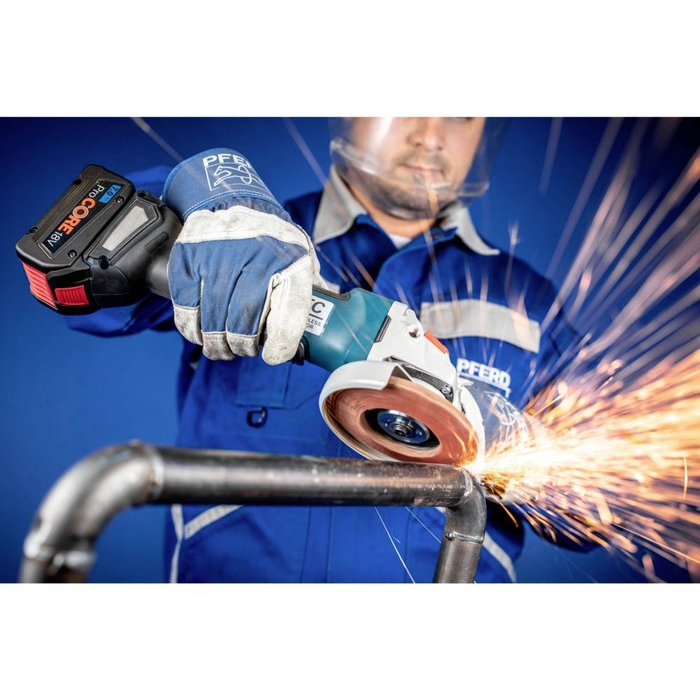 Robotnik w odzieży ochronnej szlifuje rurę metalową szlifierką kątową. Od punktu szlifowania odpryskują iskry.