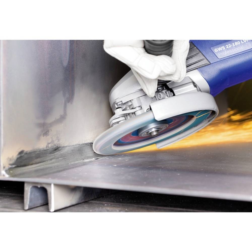 'Osoba szlifuje metal szlifierką kątową, przy czym powstają iskry. Widoczne są środki ochrony, takie jak rękawice.'