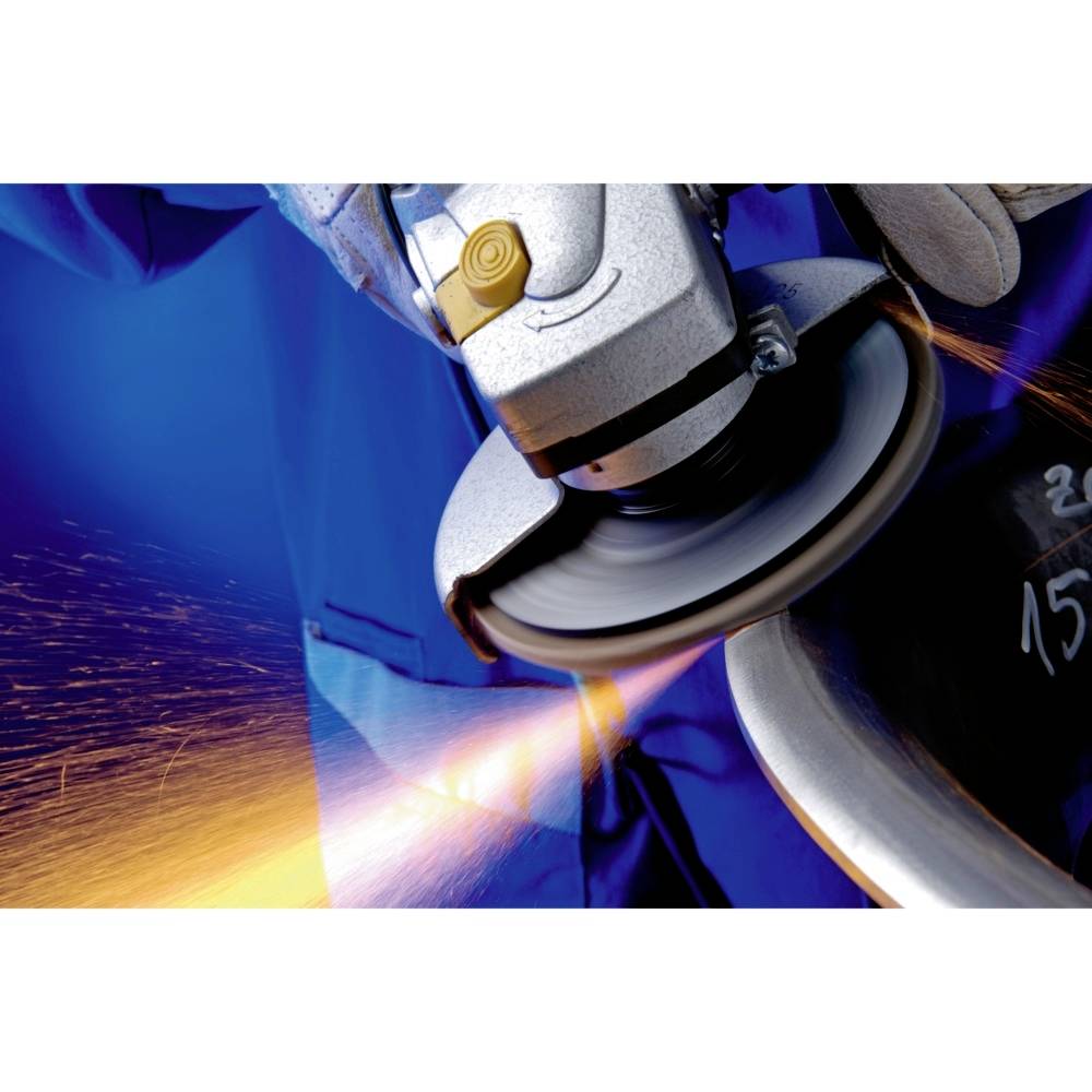 Robotnik w niebieskim ubraniu roboczym szlifuje metal szlifierką kątową, iskry lecą w lewą stronę. Wyraźnie widoczne jest wyposażenie ochronne.