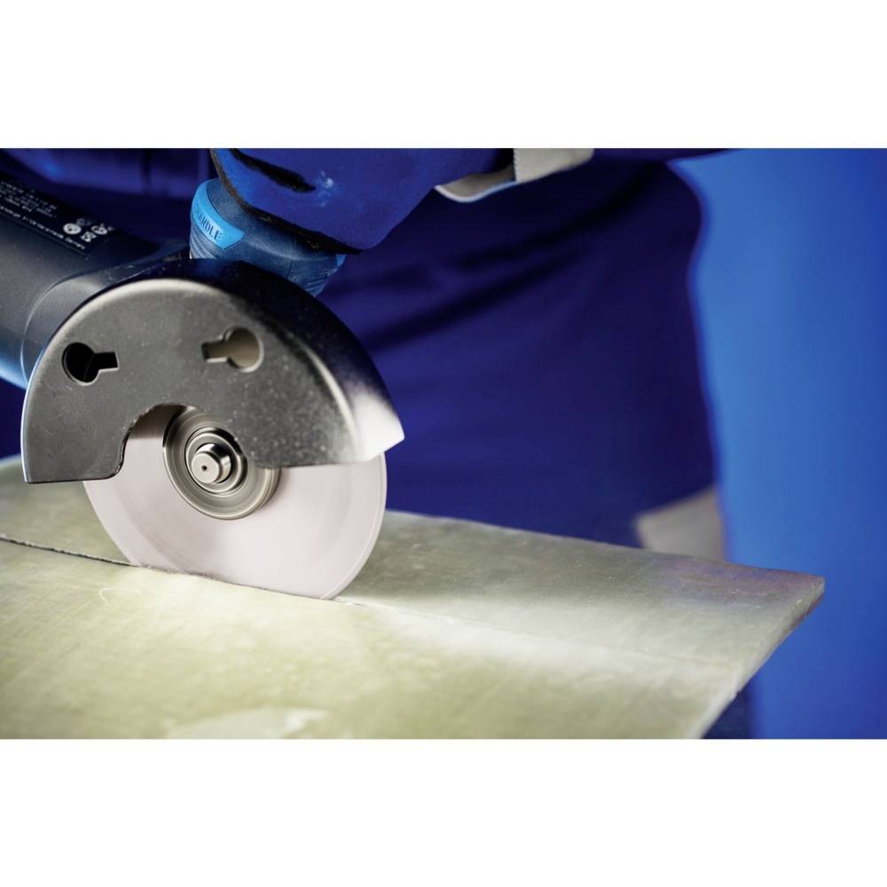 Osoba przecina arkusz metalu niebieską, elektryczną ręczną piłą tarczową. Fokus jest skierowany na proces cięcia.