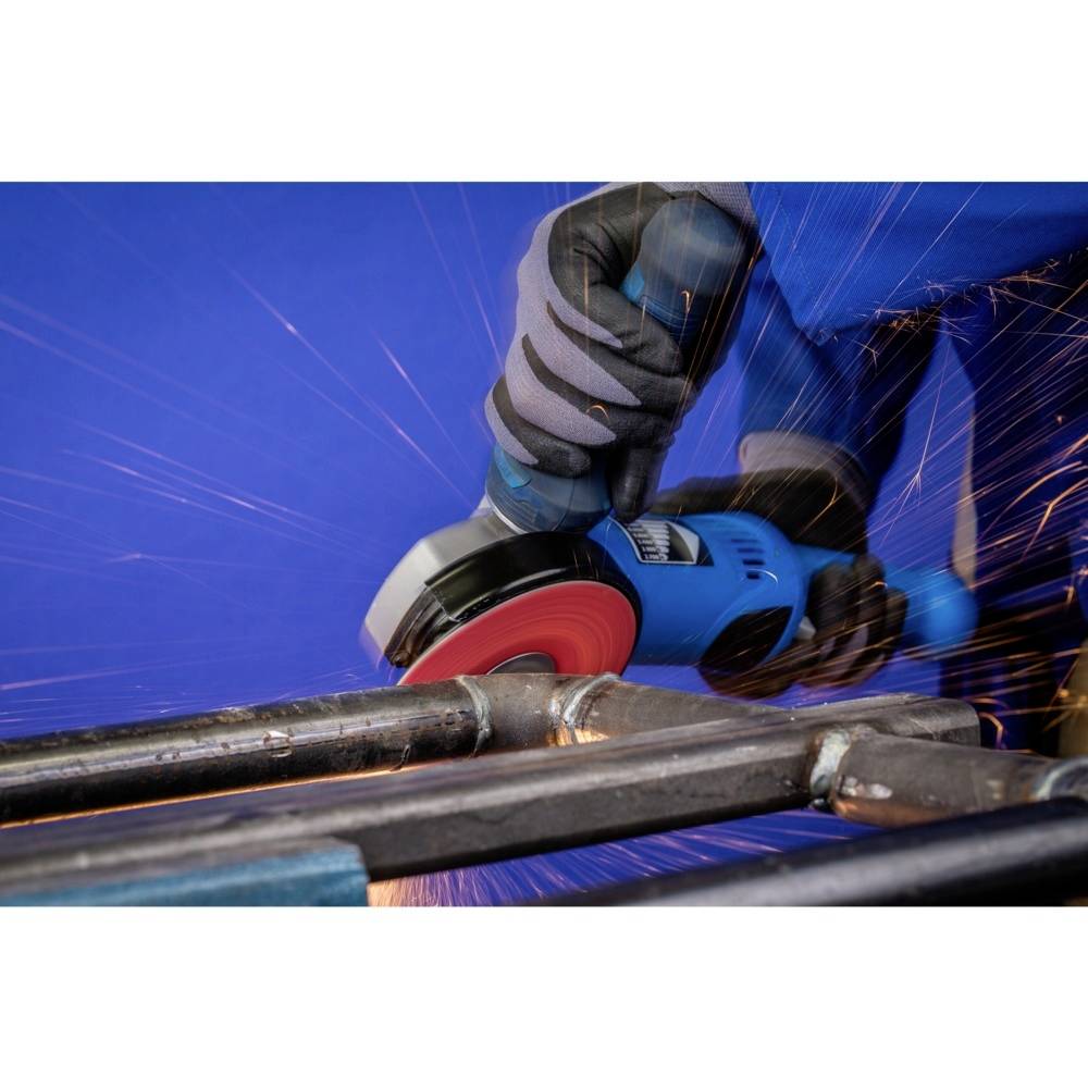 Osoba szlifuje metalowe rury niebieską szlifierką. Iskry się sypią, a rękawice chronią dłonie.
