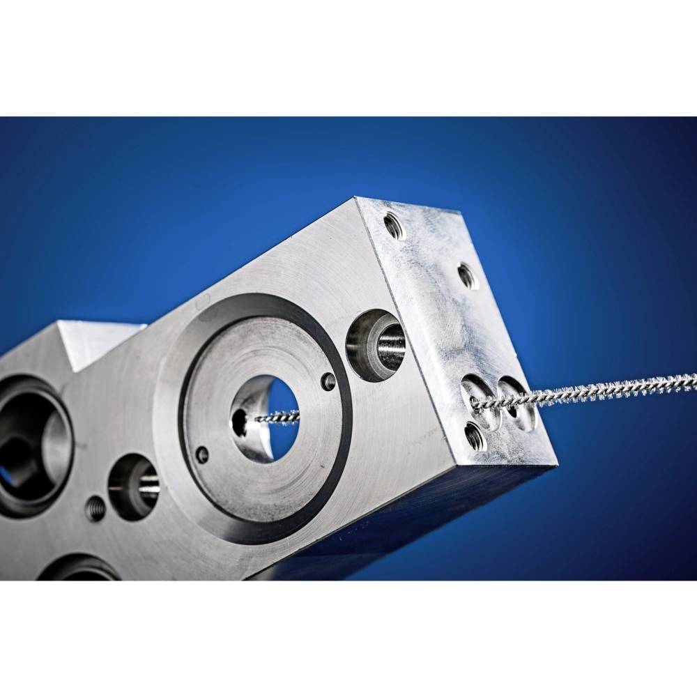 Zbliżenie metalowego elementu maszyny na niebieskim tle. Przez element przewleczony jest kabel lub przewód.