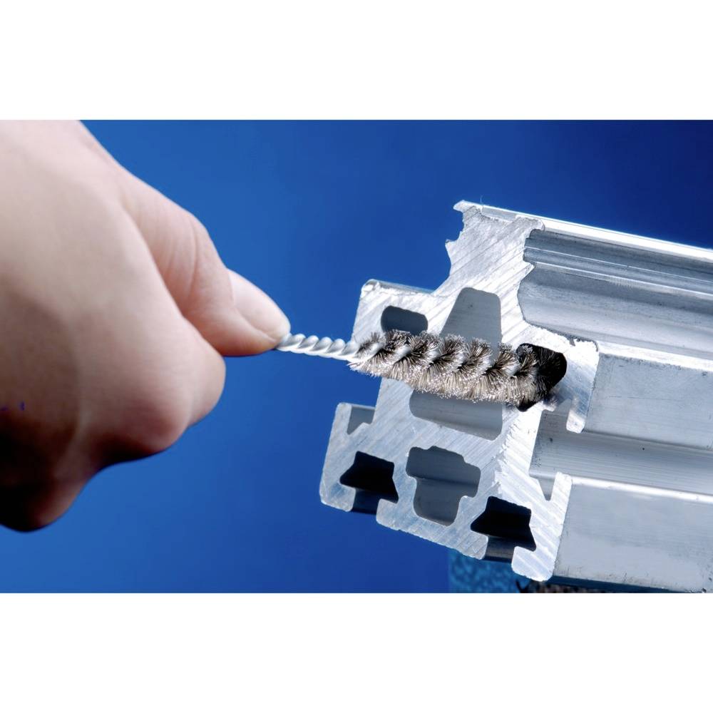 Zbliżenie przemysłowej szczotki czyszczącej usuwającej zanieczyszczenia z otworu profilu aluminiowego; nacisk na teksturę i funkcjonalność.