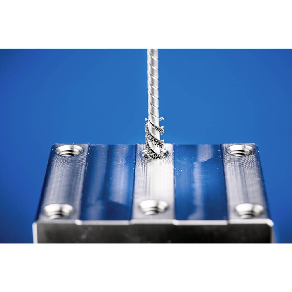 Wiertło obrabia obiekt metalowy, tworząc wióry. Zbliżenie na niebieskim tle.