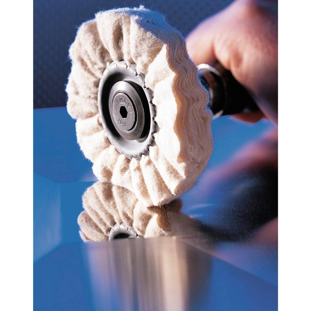 Osoba poleruje metalową powierzchnię obrotową tarczą polerską, która odbija chmury.