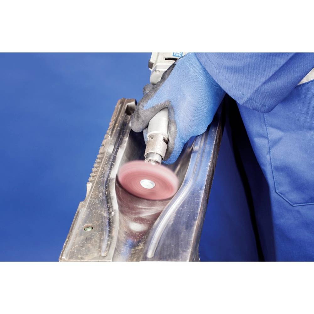 Osoba szlifuje powierzchnię metalową obrotowym narzędziem ściernym, ubrana w niebieską odzież ochronną i rękawice.