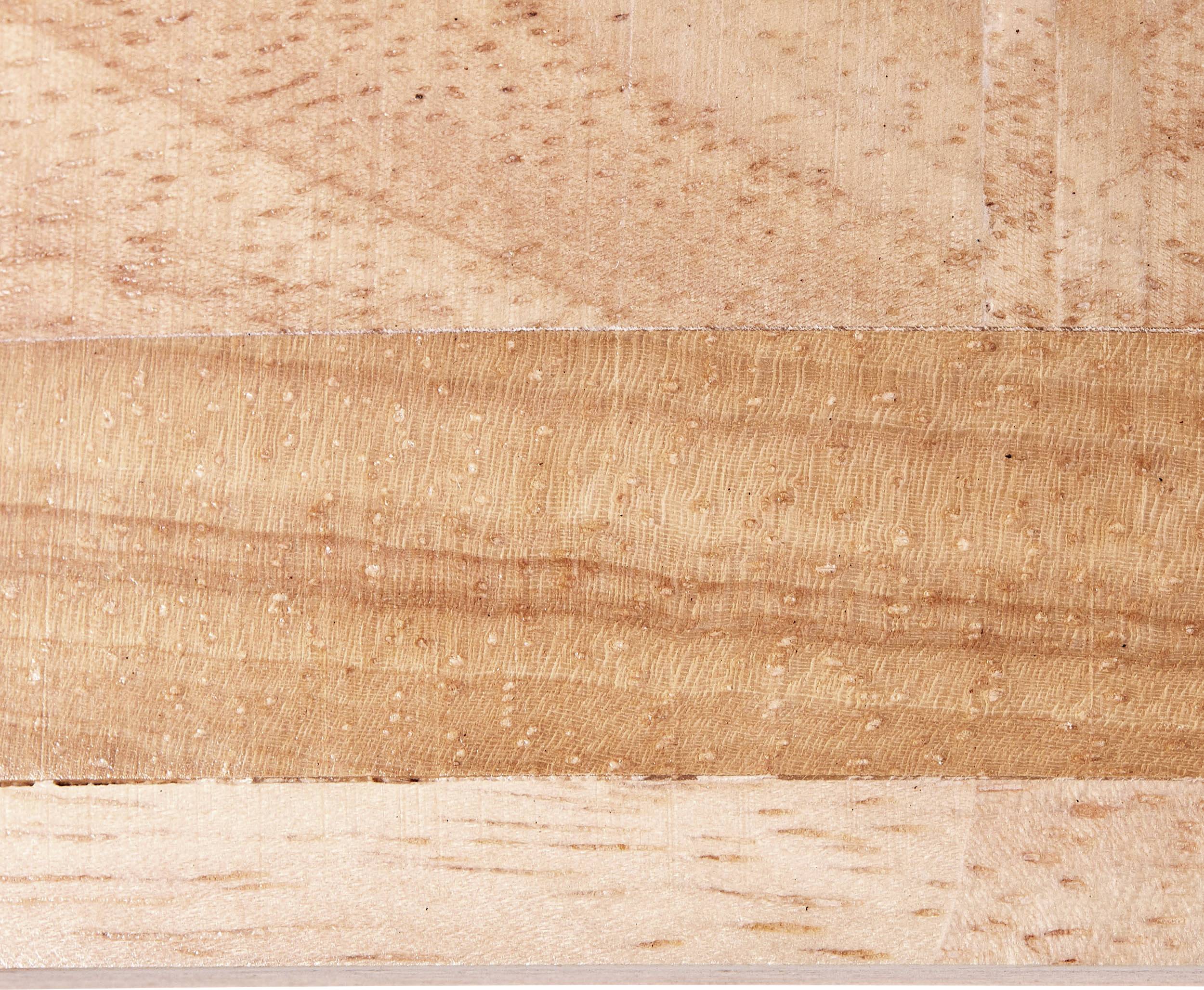 Zbliżenie powierzchni drewna z różnymi wzorami słojów i odcieniami, oferujące naturalny, strukturalny wygląd.