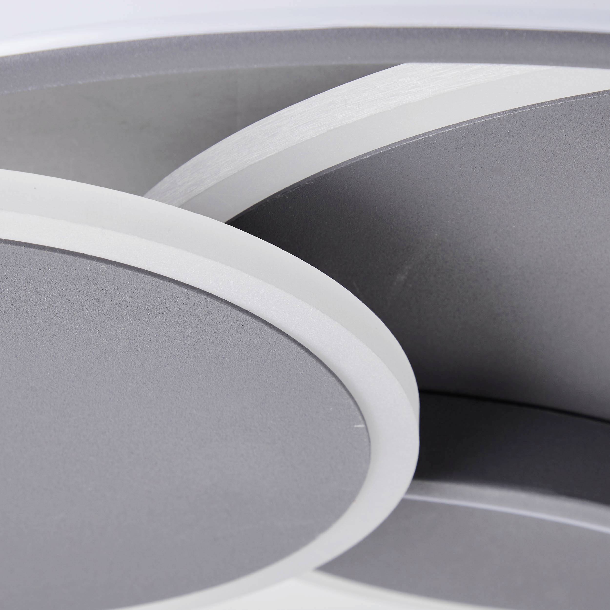 Okrągła, srebrna lampa sufitowa z nowoczesnymi, wzajemnie zaplecionymi pierścieniami.